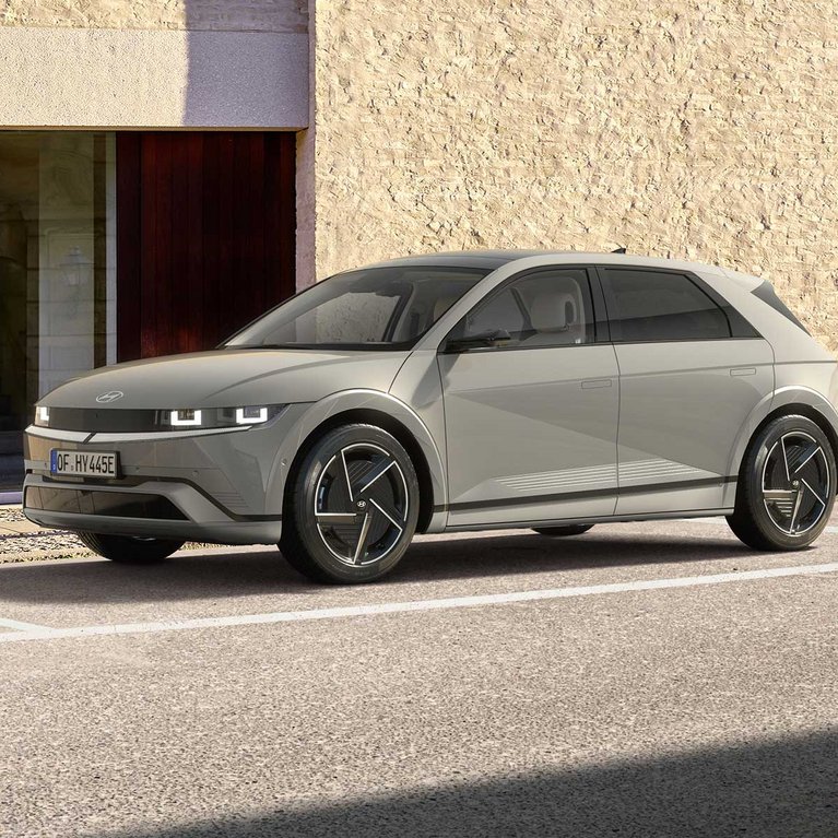 Grauer Hyundai IONIQ 5 in Seitenansicht vor einem modernen Gebäude