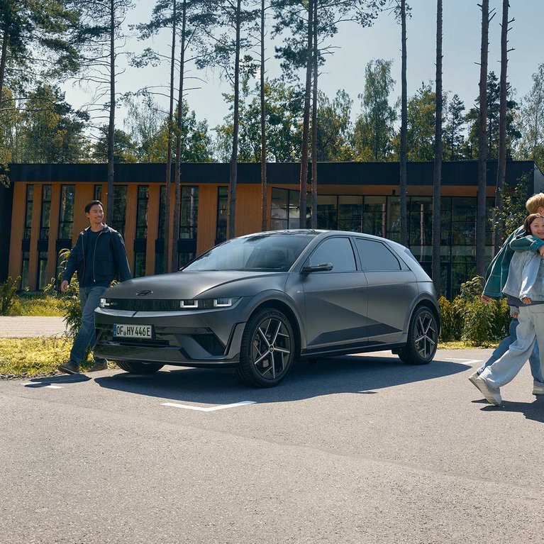 Hyundai IONIQ 5 vor einem modernen Gebäude in naturnaher Umgebung